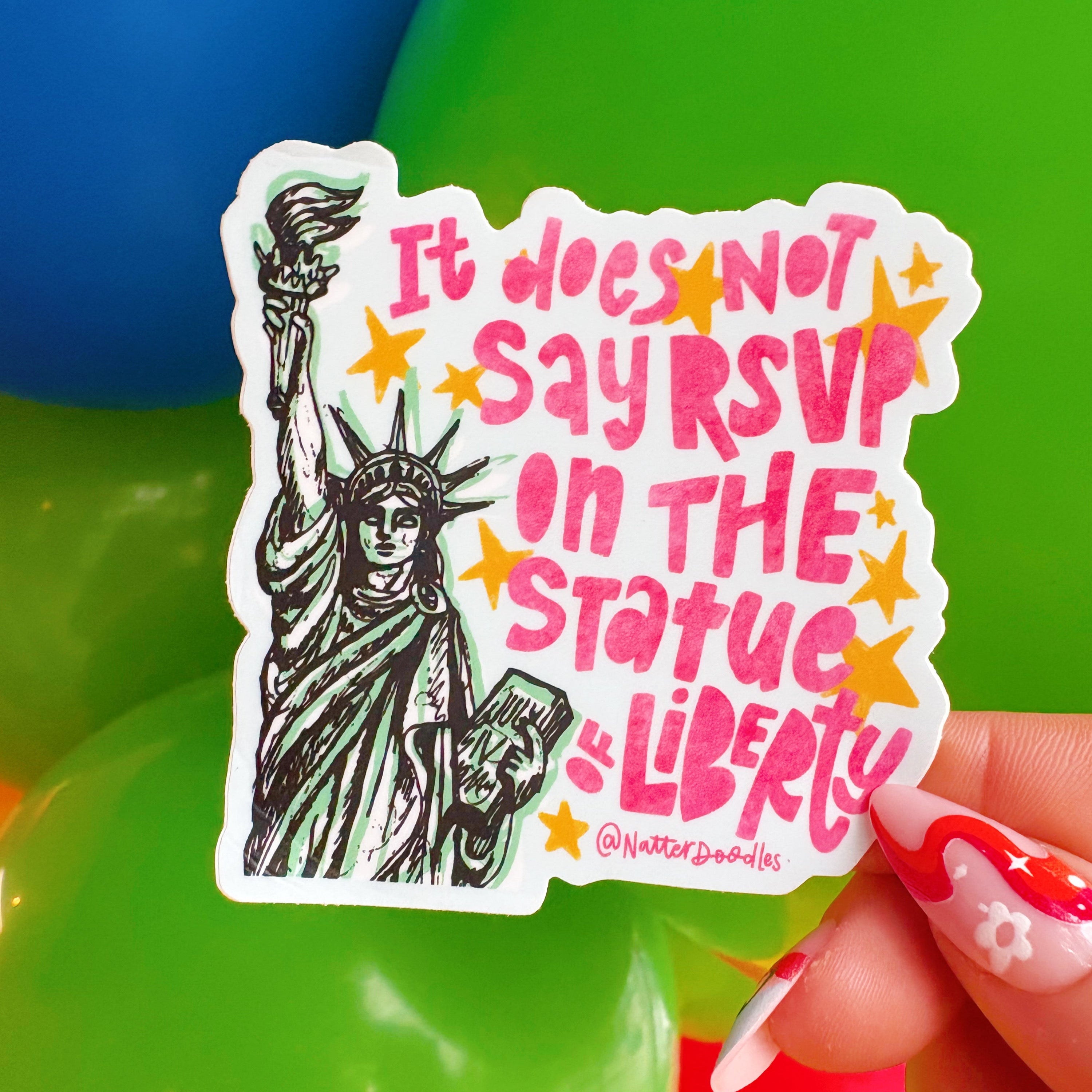Sticker with Statue of Liberty design and text held by a hand against a colorful background