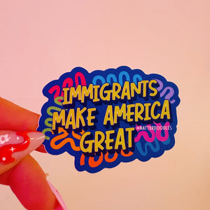 Sticker with 'Immigrants Make America Great' text held by a hand on a pink background