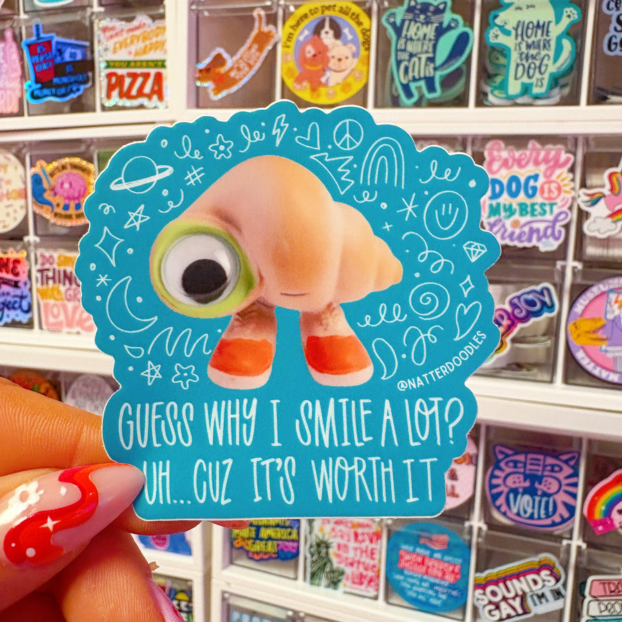 Sticker with a cartoon character and text held in front of red balloons