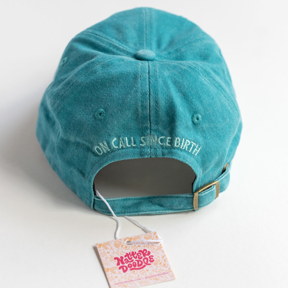 Back of the dad cap with On Call Since Birth embroidery and gold-tone metal clasp