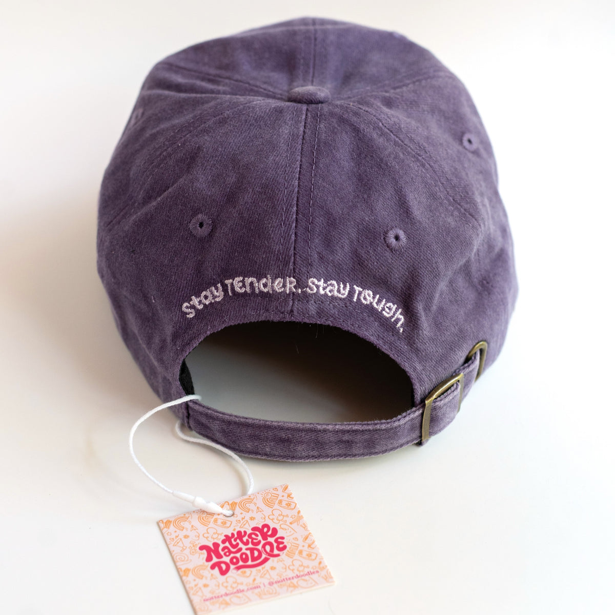 Back of the dad cap with Stay Tender, Stay Tough embroidery and gold-tone metal clasp