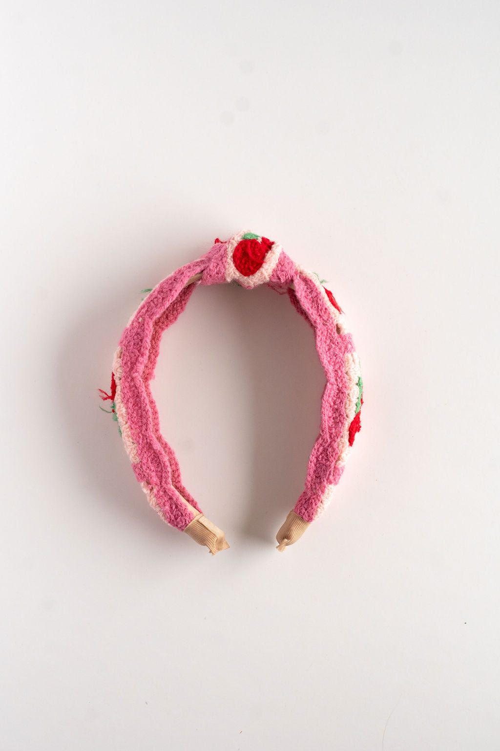 Pink headband with red heart decorations on a white background
