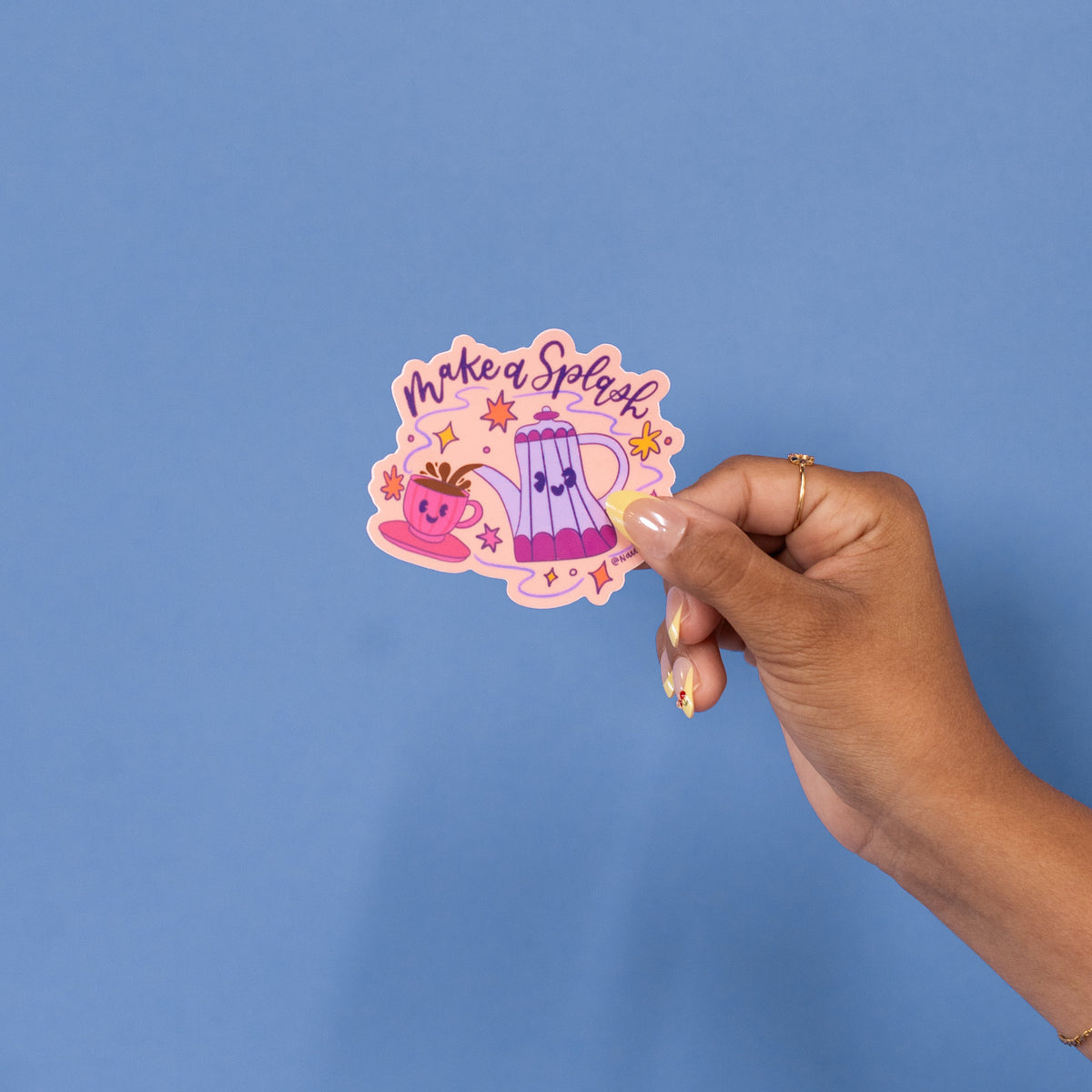 Close-up of the smiling coffee pot and pink cup with saucer on the Make a Splash sticker