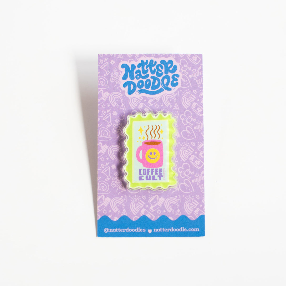 Coffee Cult acrylic pin with a pink coffee mug and yellow smiley face in a neon green stamp border, on a NatterDoodle card