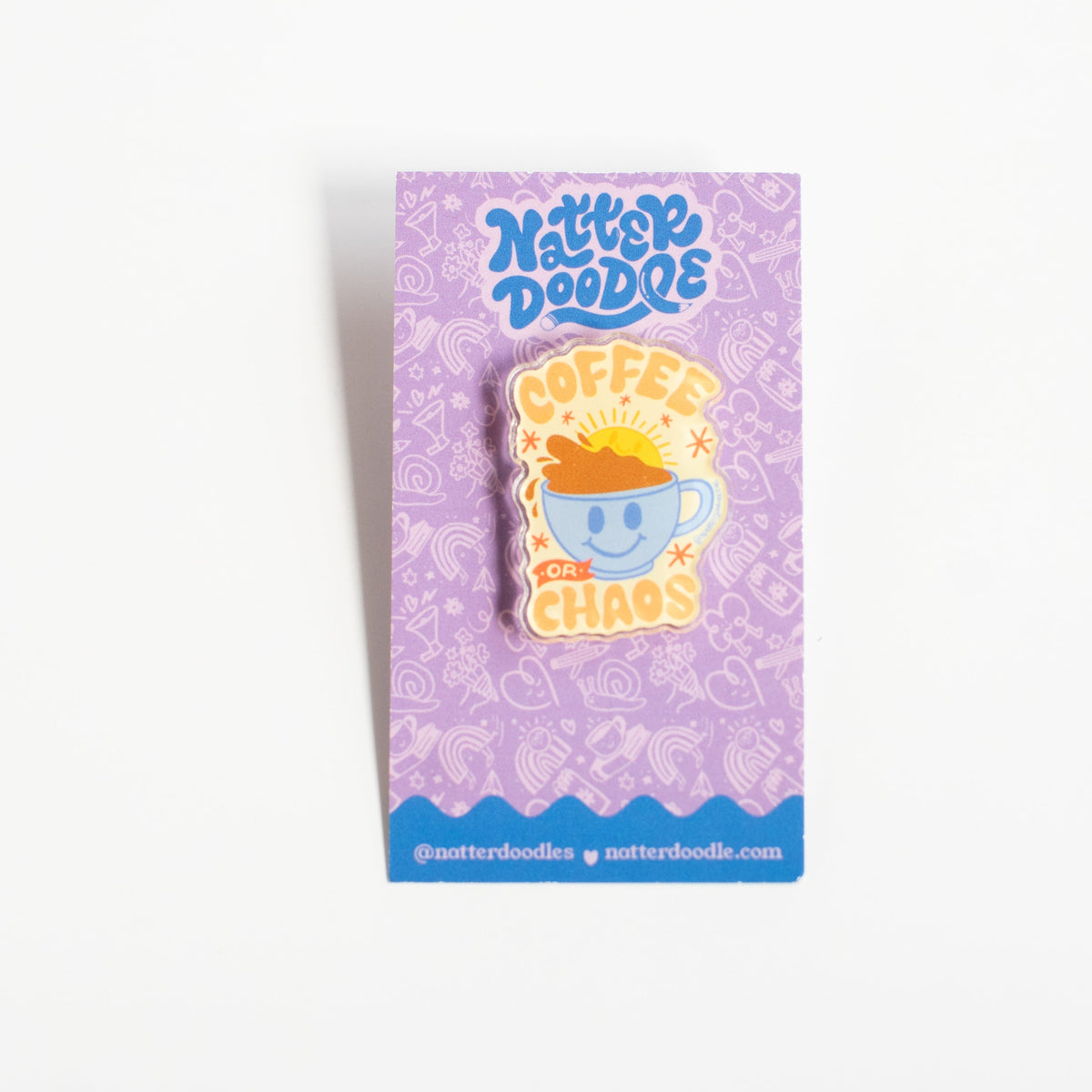 Coffee or Chaos acrylic pin with a smiling blue mug overflowing with coffee, on a NatterDoodle backing card