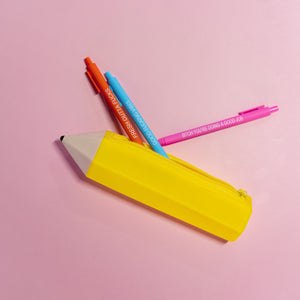 Colorful pens and a yellow pencil sharpener on a pink background