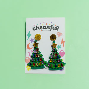 Colorful Christmas tree earrings on a 'cheerful' branded card against a light green background