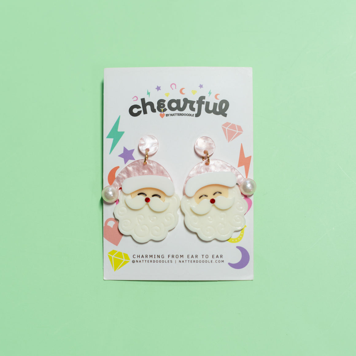 Packaged earrings with Santa Claus design on a green background