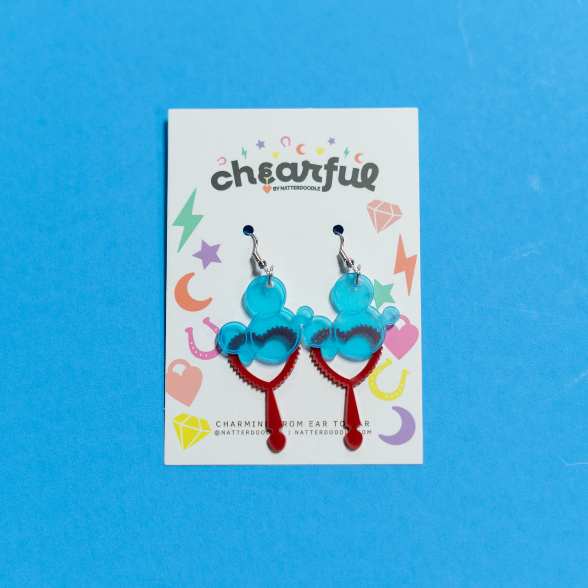 Pair of blue and red earrings on a 'cheerful' branded card against a blue background