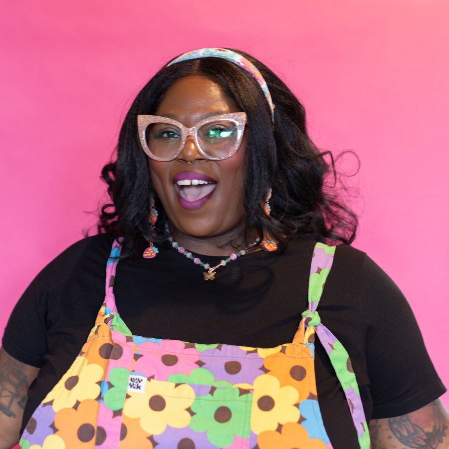 Woman wearing colorful accessories against a pink background