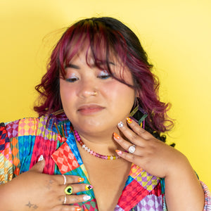 Woman wearing a colorful checkered shirt against a yellow background