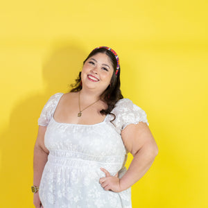 Woman wearing a white dress against a yellow background