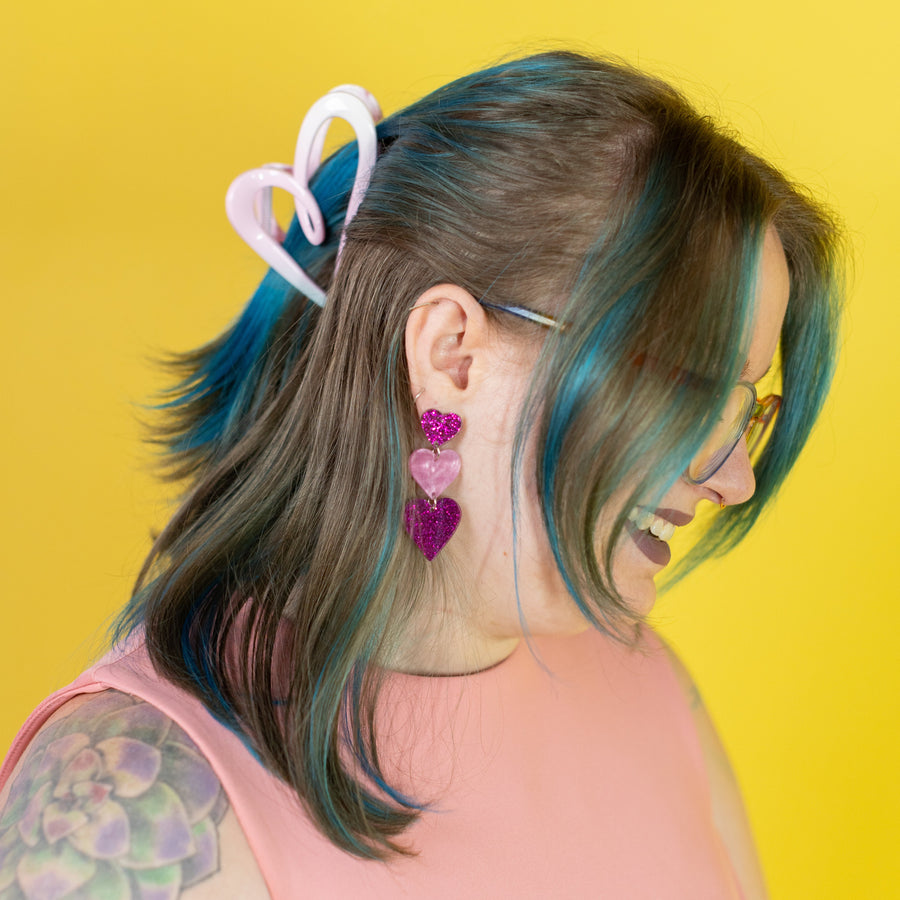 Person with colorful hair accessories against a yellow background