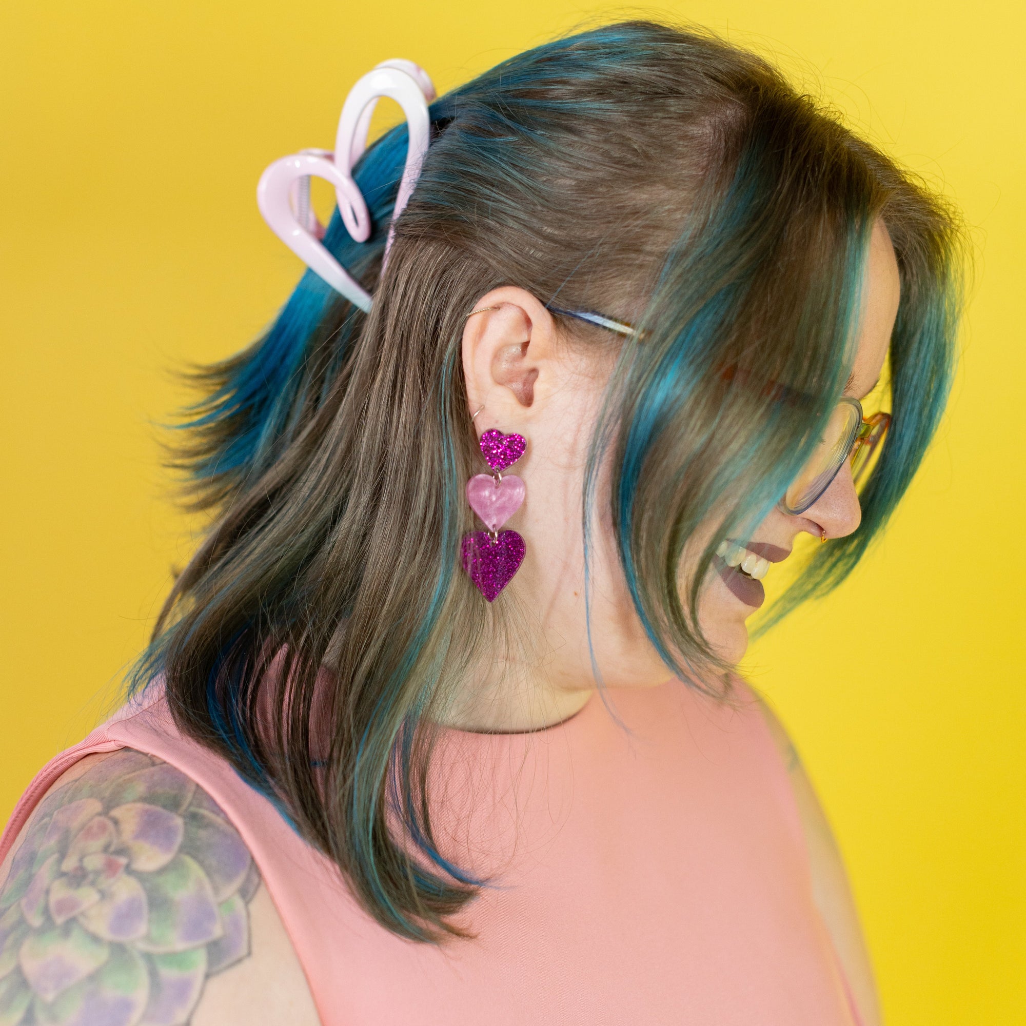 Person with colorful hair accessories against a yellow background