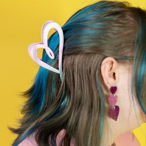 Person with colorful hair and accessories against a yellow background
