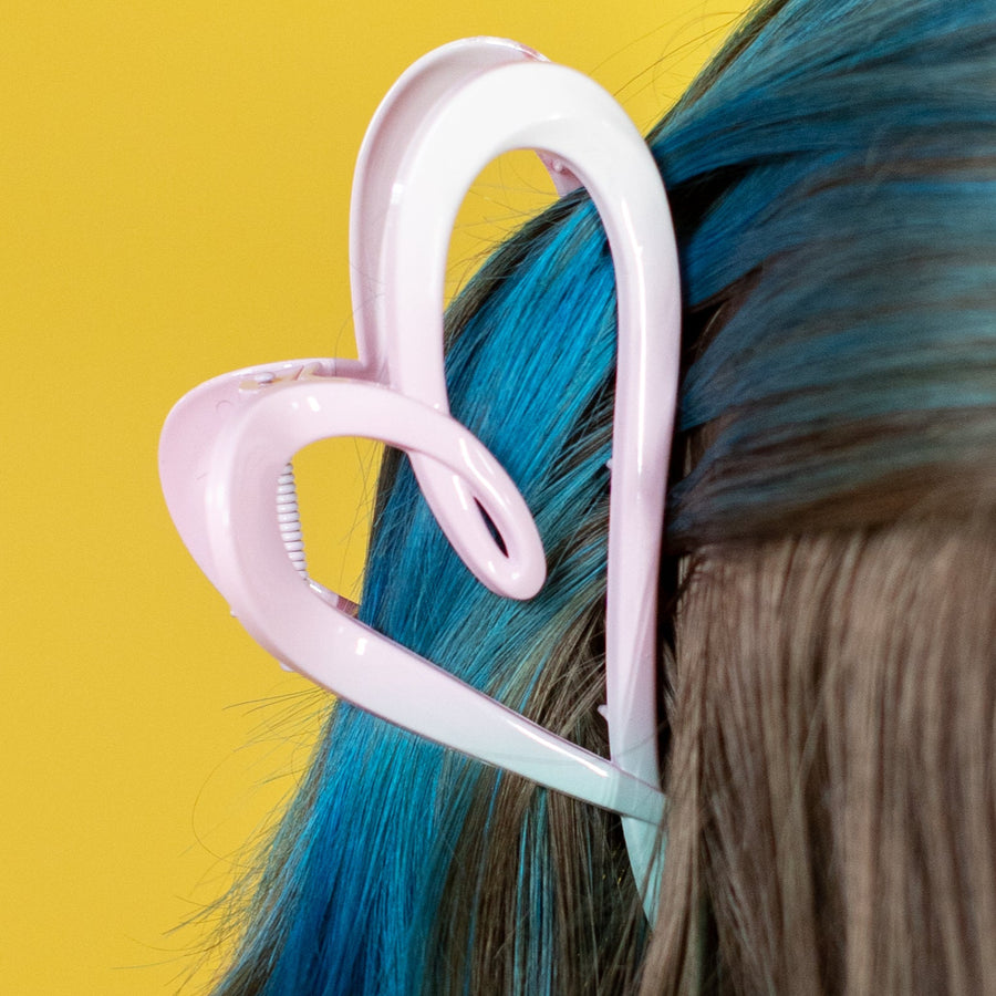 Person with colorful hair accessories against a yellow background