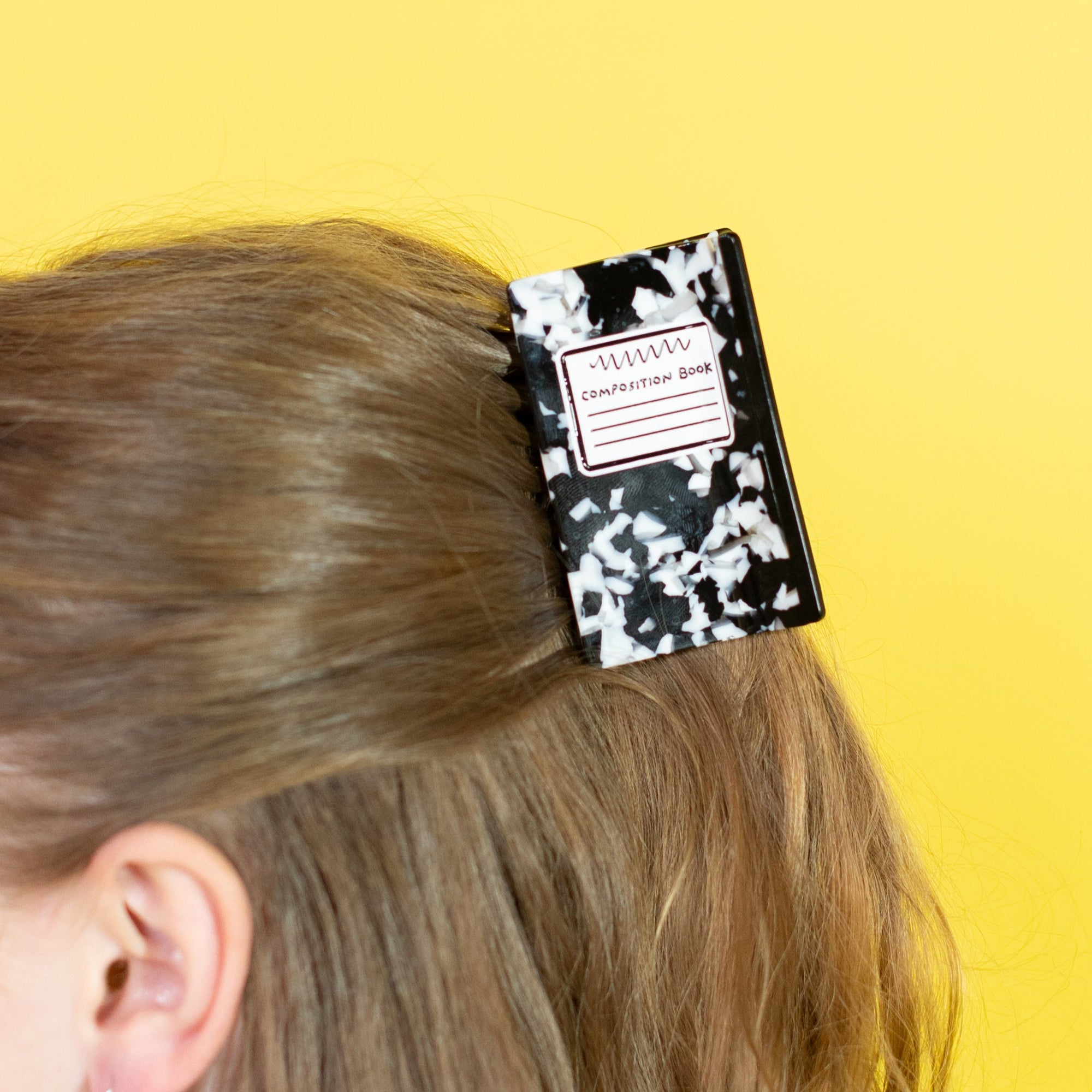 Woman with a black and white hair clip on a yellow background