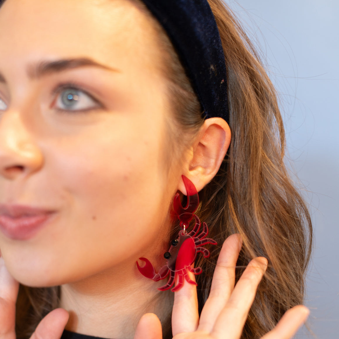 Woman wearing red earrings with a neutral background