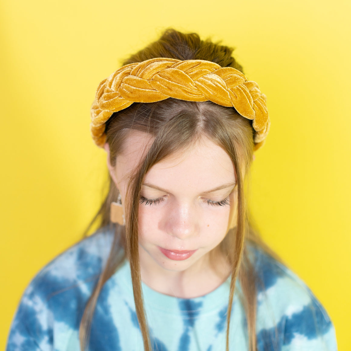 Person wearing a yellow headband against a yellow background