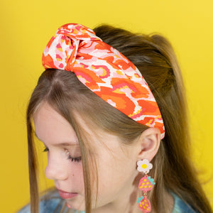 Girl wearing a colorful headband with a yellow background
