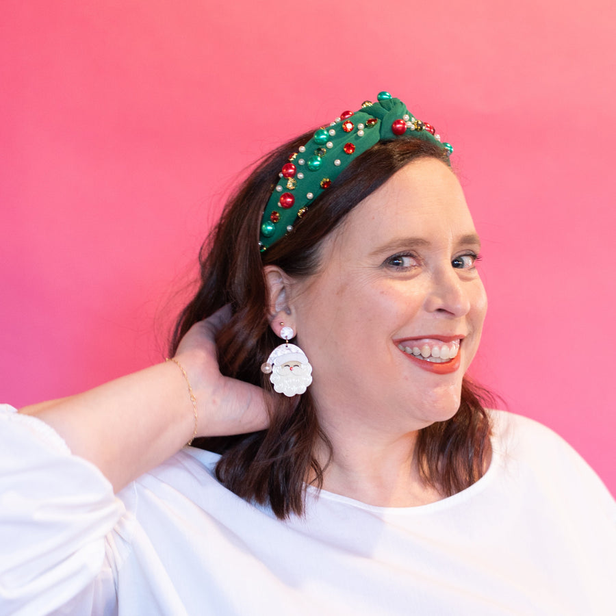 Packaged earrings with Santa Claus design on a green background