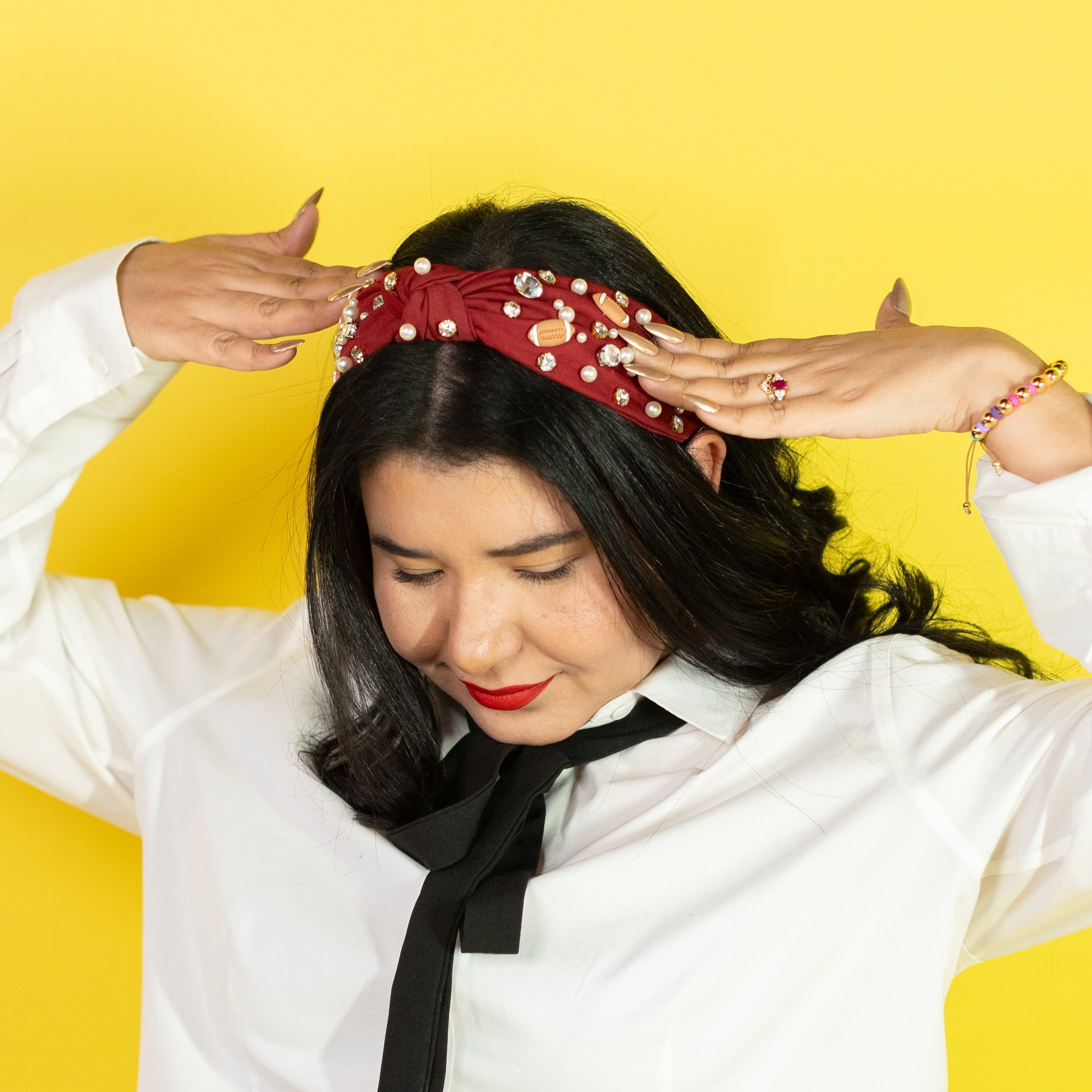 Person wearing a white shirt, black pants, and a red headband against a yellow background