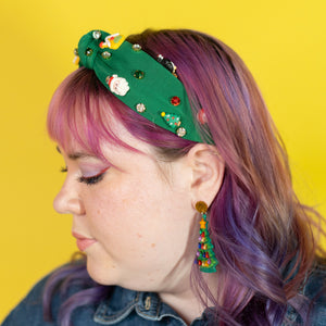Person with colorful hair and accessories against a yellow background
