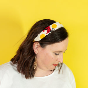 Woman wearing a colorful headband against a yellow background