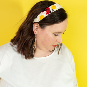 Woman wearing a colorful headband against a yellow background