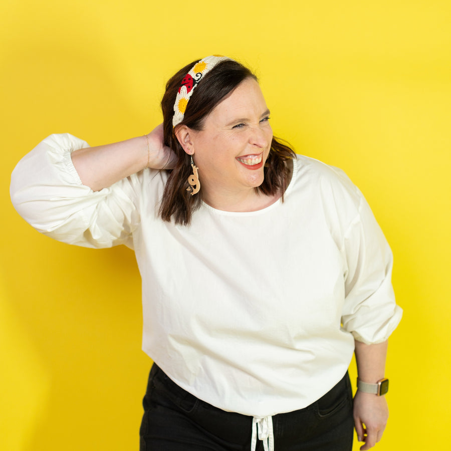 Woman wearing a colorful headband against a yellow background