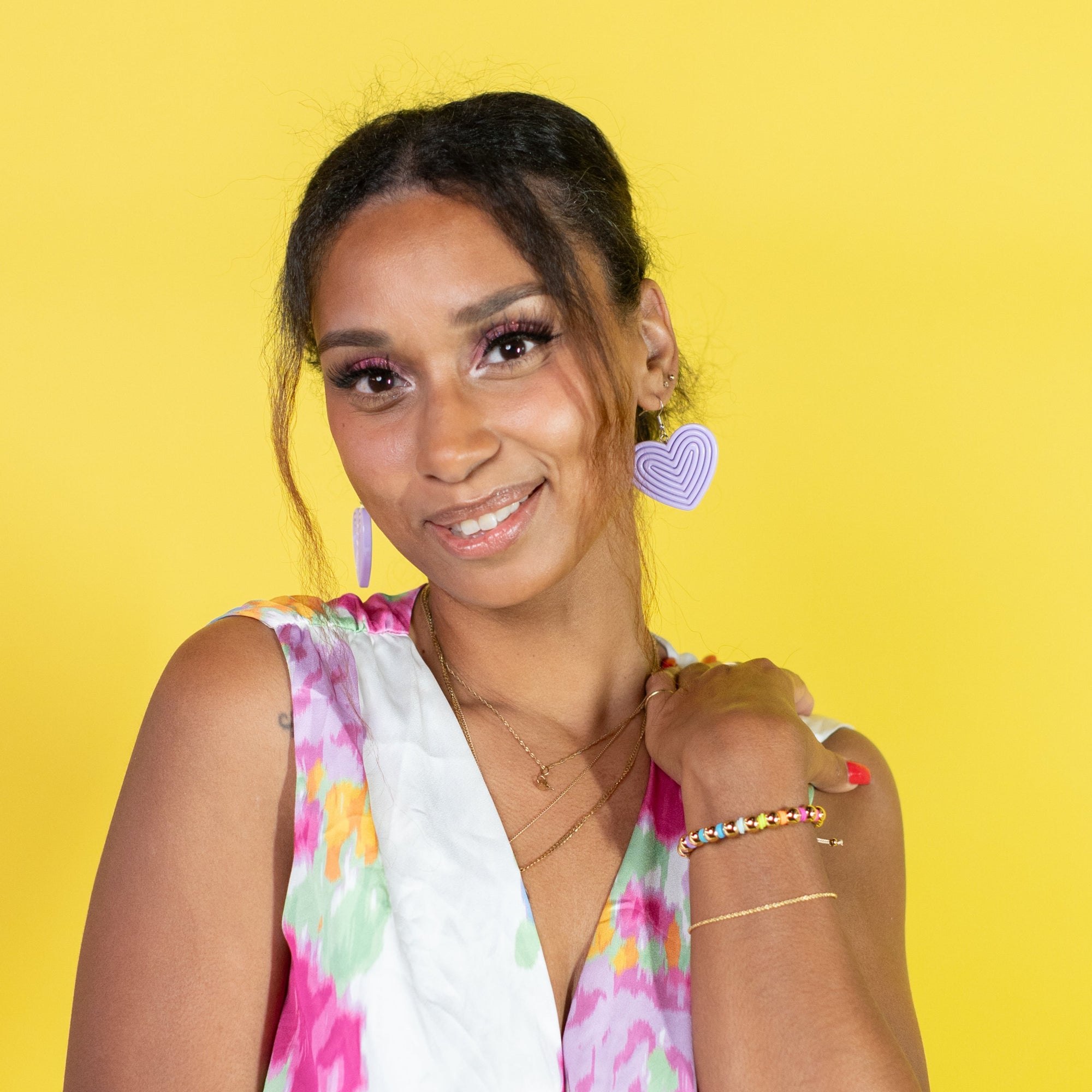 Woman wearing a colorful floral dress against a yellow background