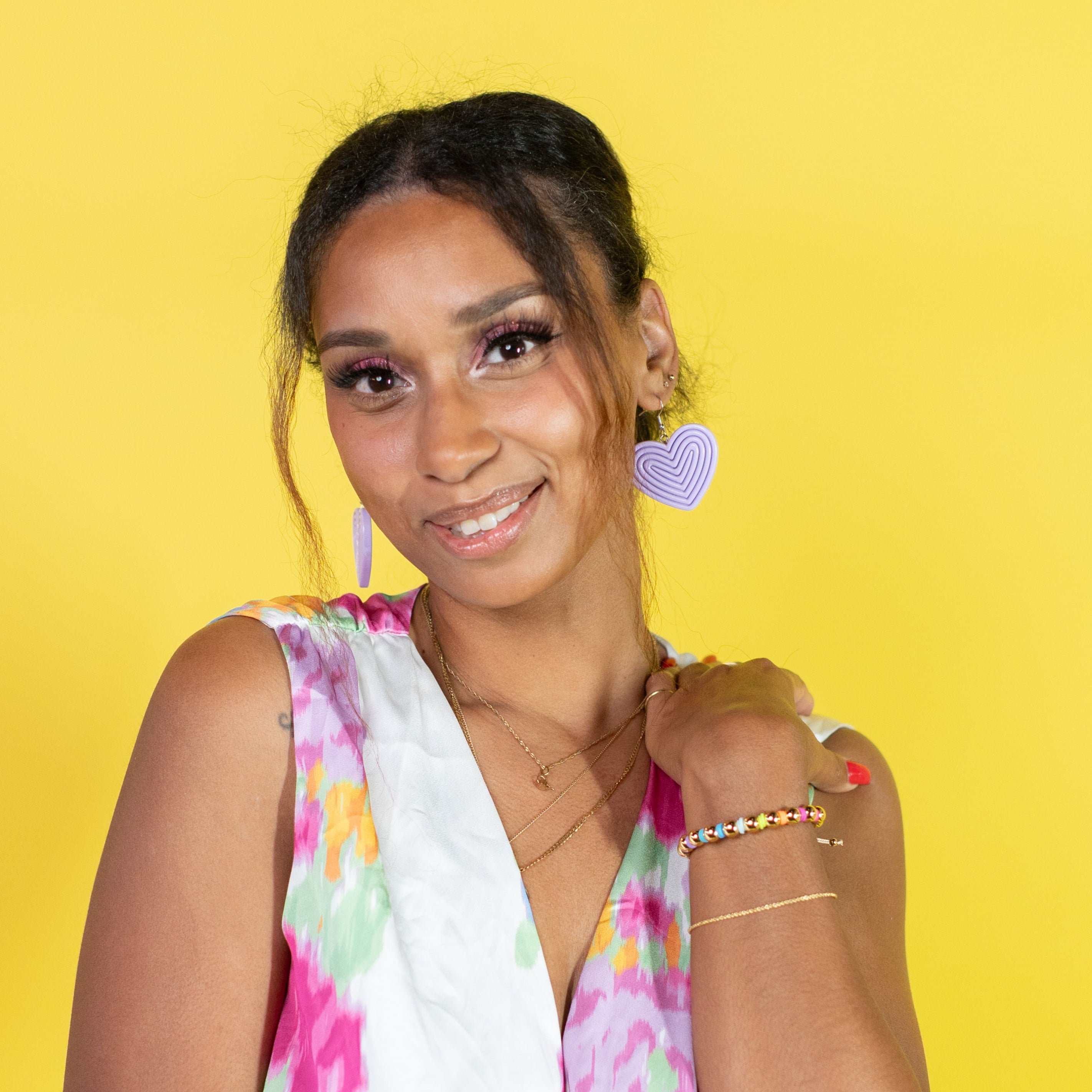Woman wearing a colorful floral dress against a yellow background