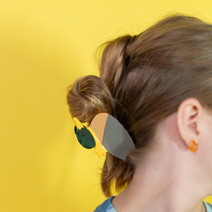 Person wearing colorful sunglasses with a yellow background