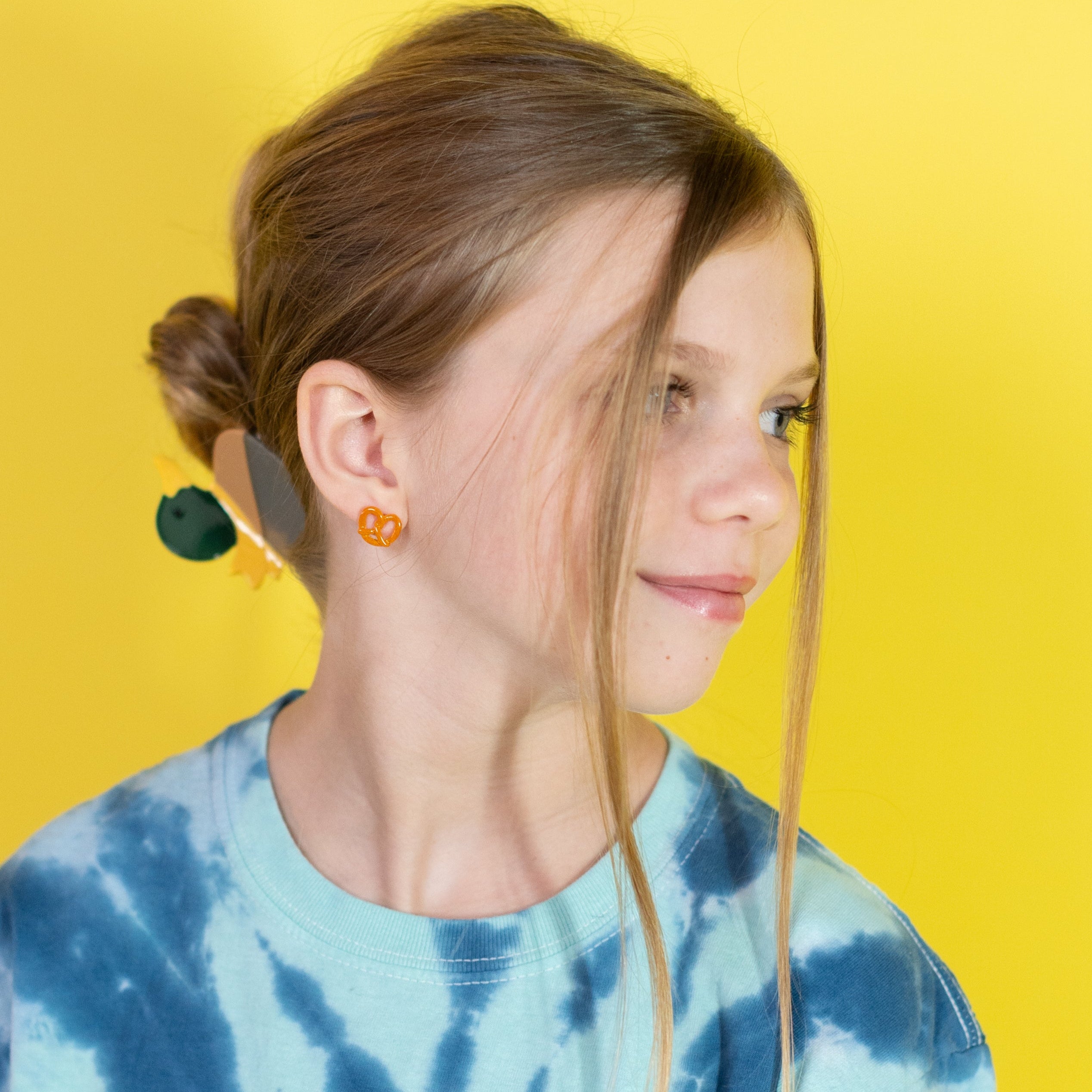 Person wearing a blue tie-dye shirt against a yellow background