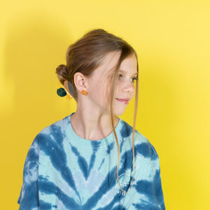 Person wearing a blue tie-dye shirt against a yellow background