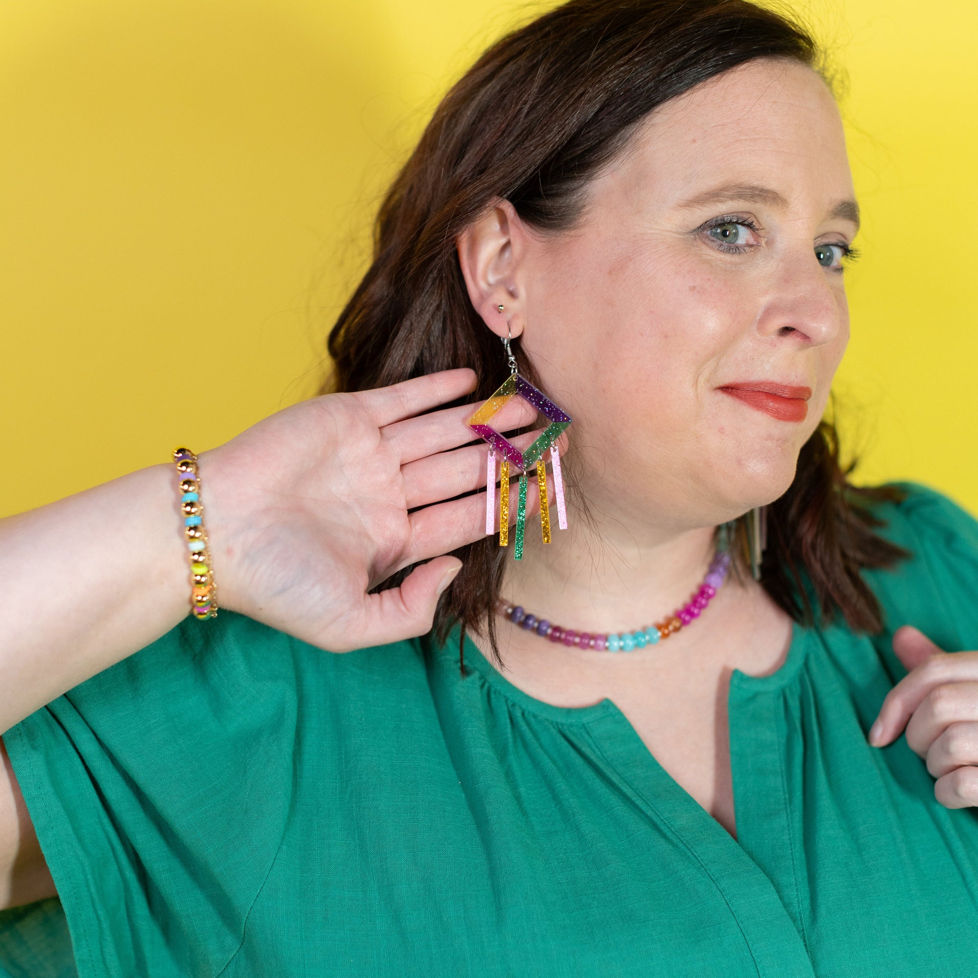 Woman wearing colorful jewelry against a yellow background