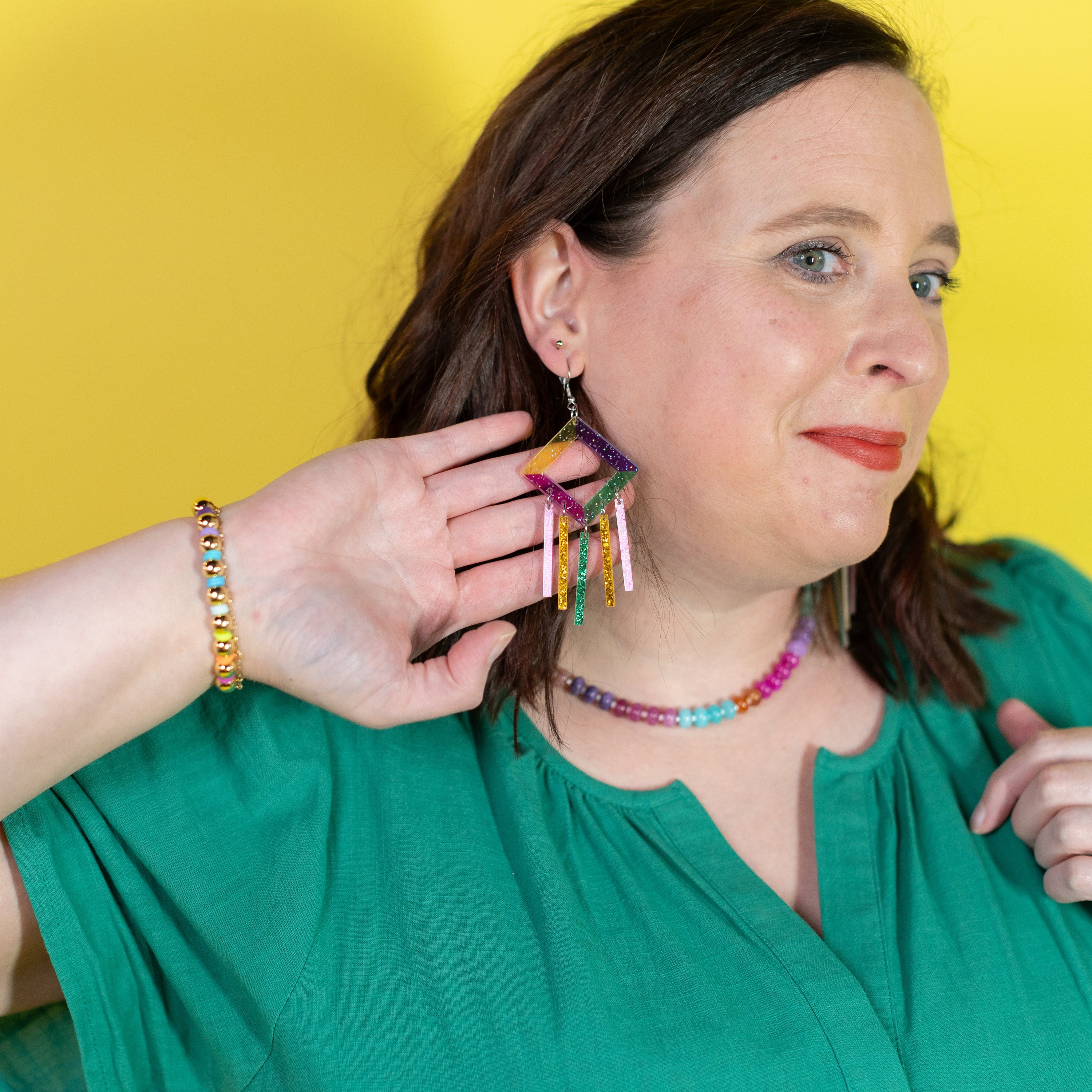 Woman wearing colorful jewelry against a yellow background