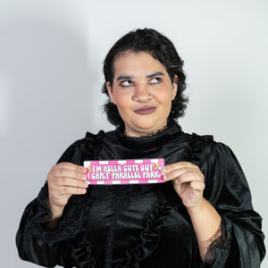 Person wearing a black outfit holding a pink card with text on a white background