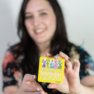 Woman holding a colorful card with cartoon characters against a plain background