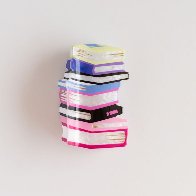 Stack of colorful rectangular books hair claw on a light gray background