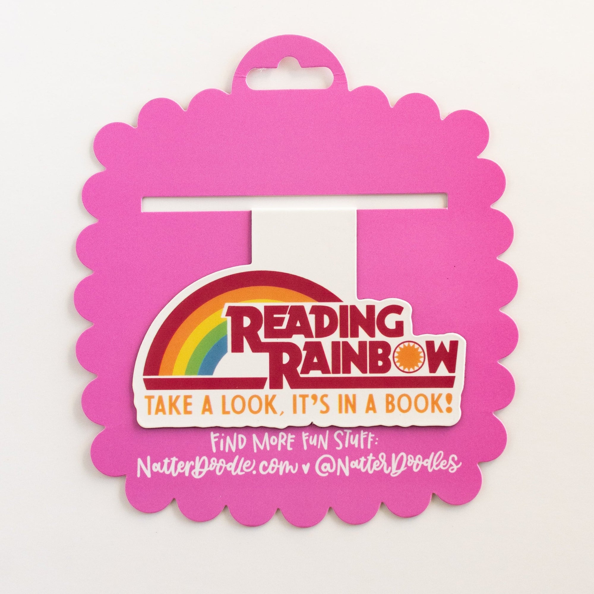 Pink Reading Rainbow book with a rainbow logo on a white background