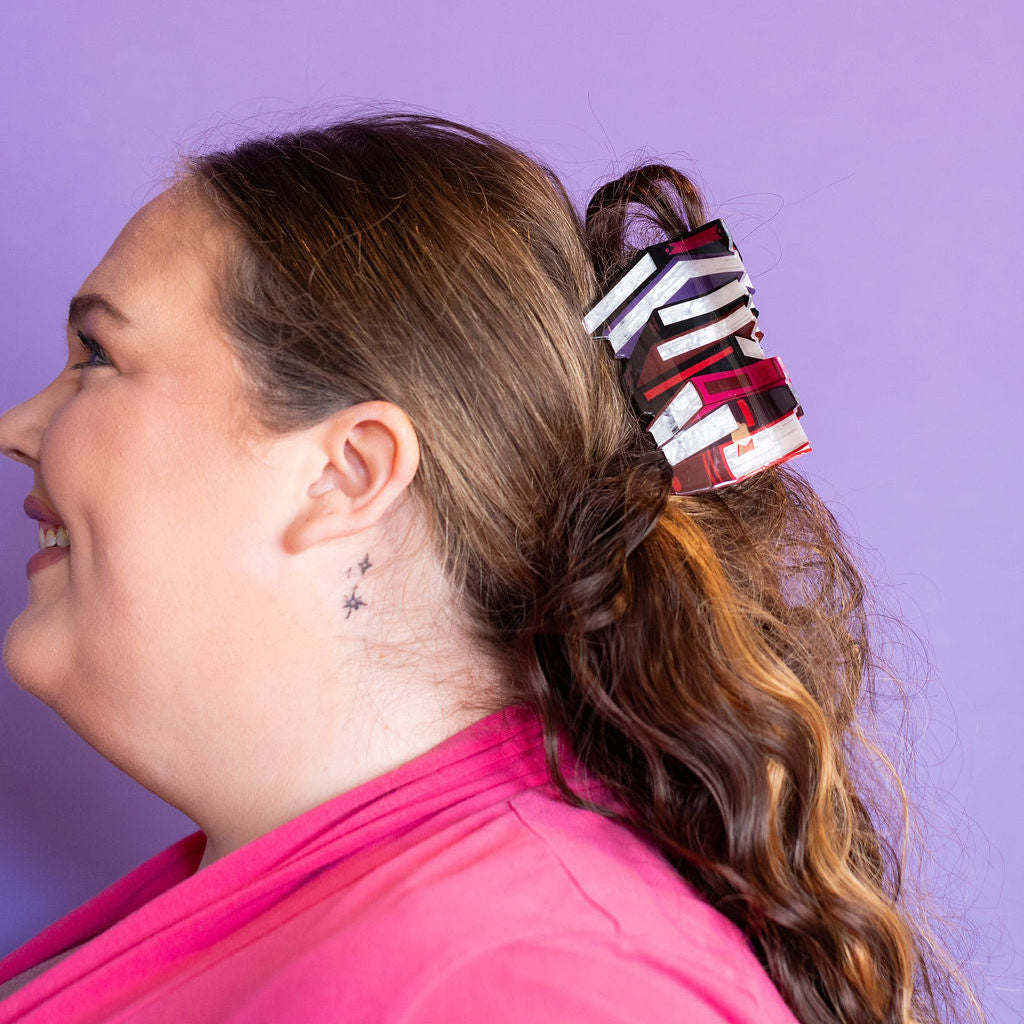 Woman with a ponytail featuring a striped hair tie against a purple background