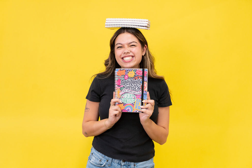Person holding a colorful book against a yellow background
