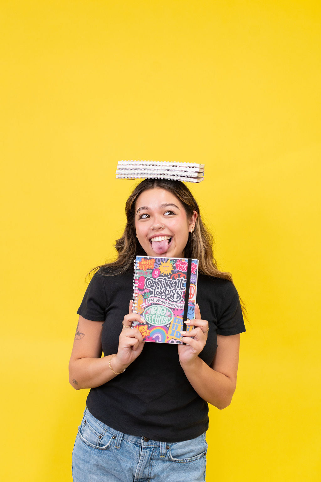 Person holding a colorful book with a yellow background