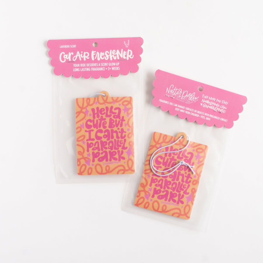 Pink car air freshener with colorful text on a white background
