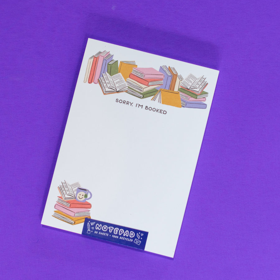 Notepad with colorful books illustration and 'Sorry, I'm Booked' text on a white background