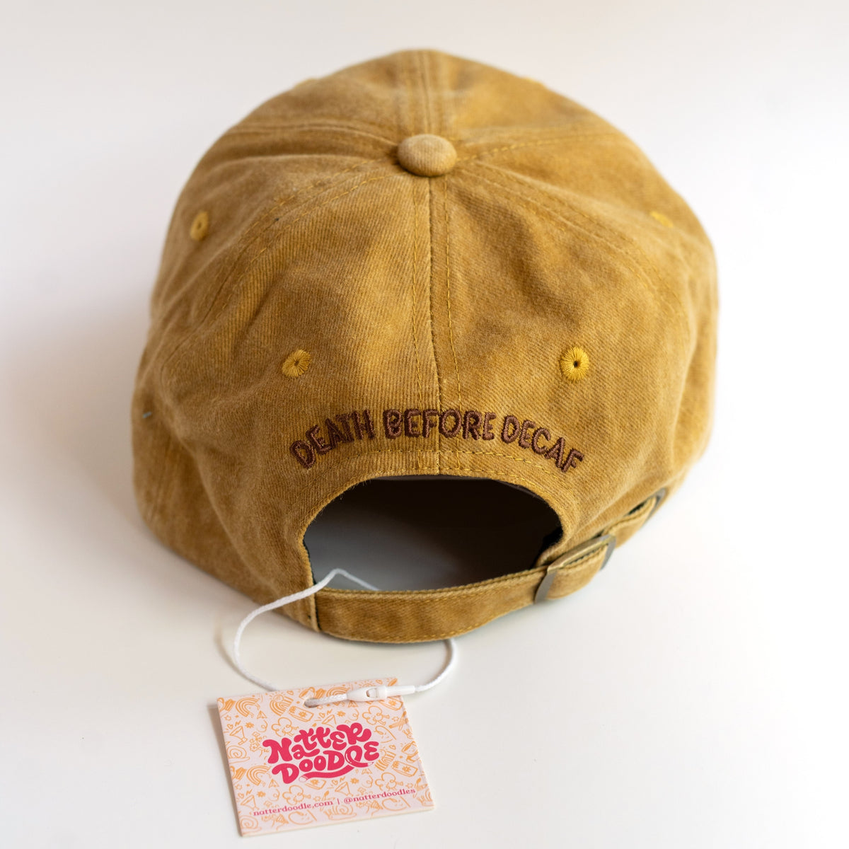 Front of Coffee Cult dad hat showing groovy brown Coffee Cult embroidery on a mustard gold cap