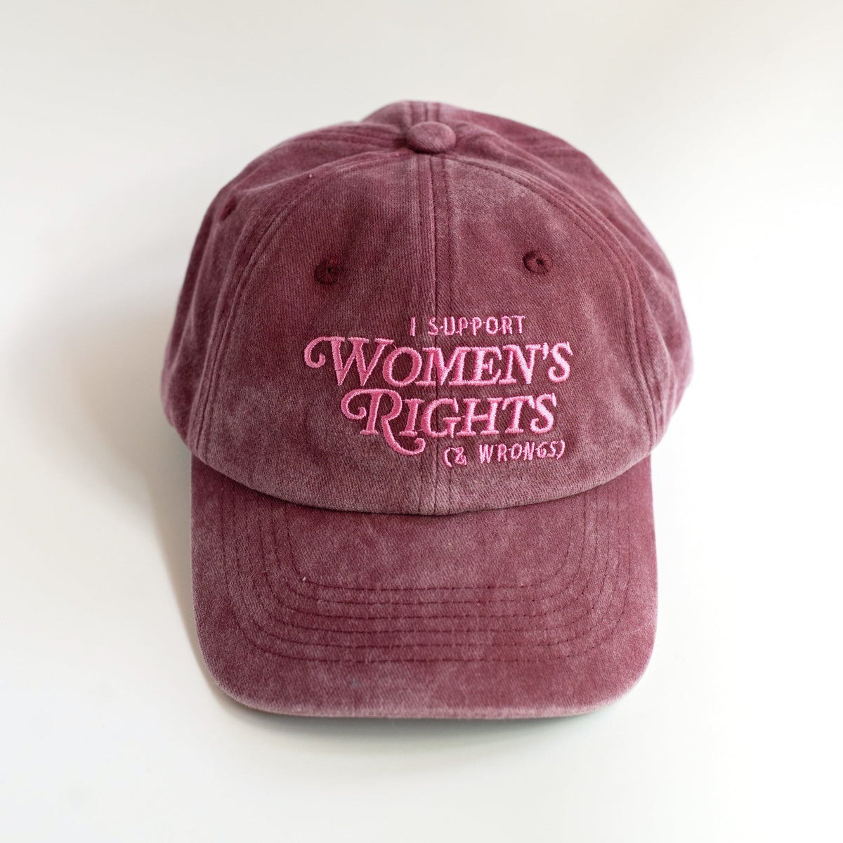 Front of burgundy dad hat with pink I Support Women's Rights & Wrongs embroidery