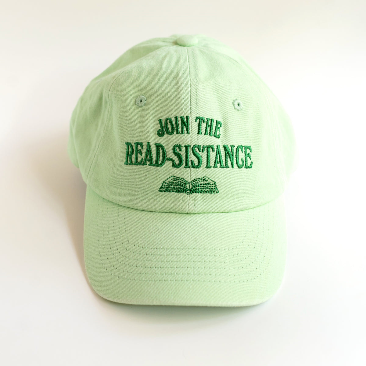 Join the Read-sistance mint green dad cap with dark green embroidered lettering and open book, front view