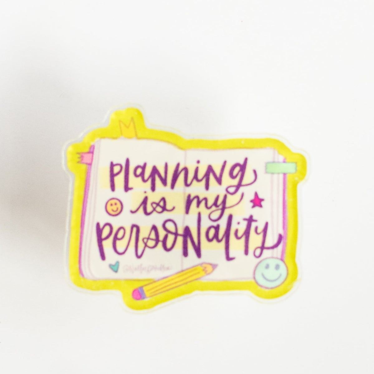 Front view of Planning Is My Personality glossy acrylic pin with yellow pencil, tabs and smiley faces